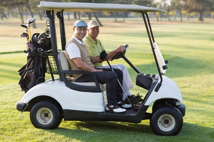 Two men driving on grass | JOY RIDEHappy male golfer friends buggy | Joy Ride